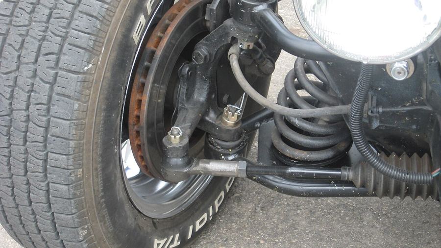 Close-up of a car front wheel with a coil spring in the suspension